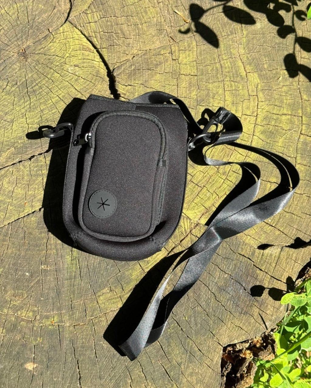 Black crossbody bag on a wooden surface