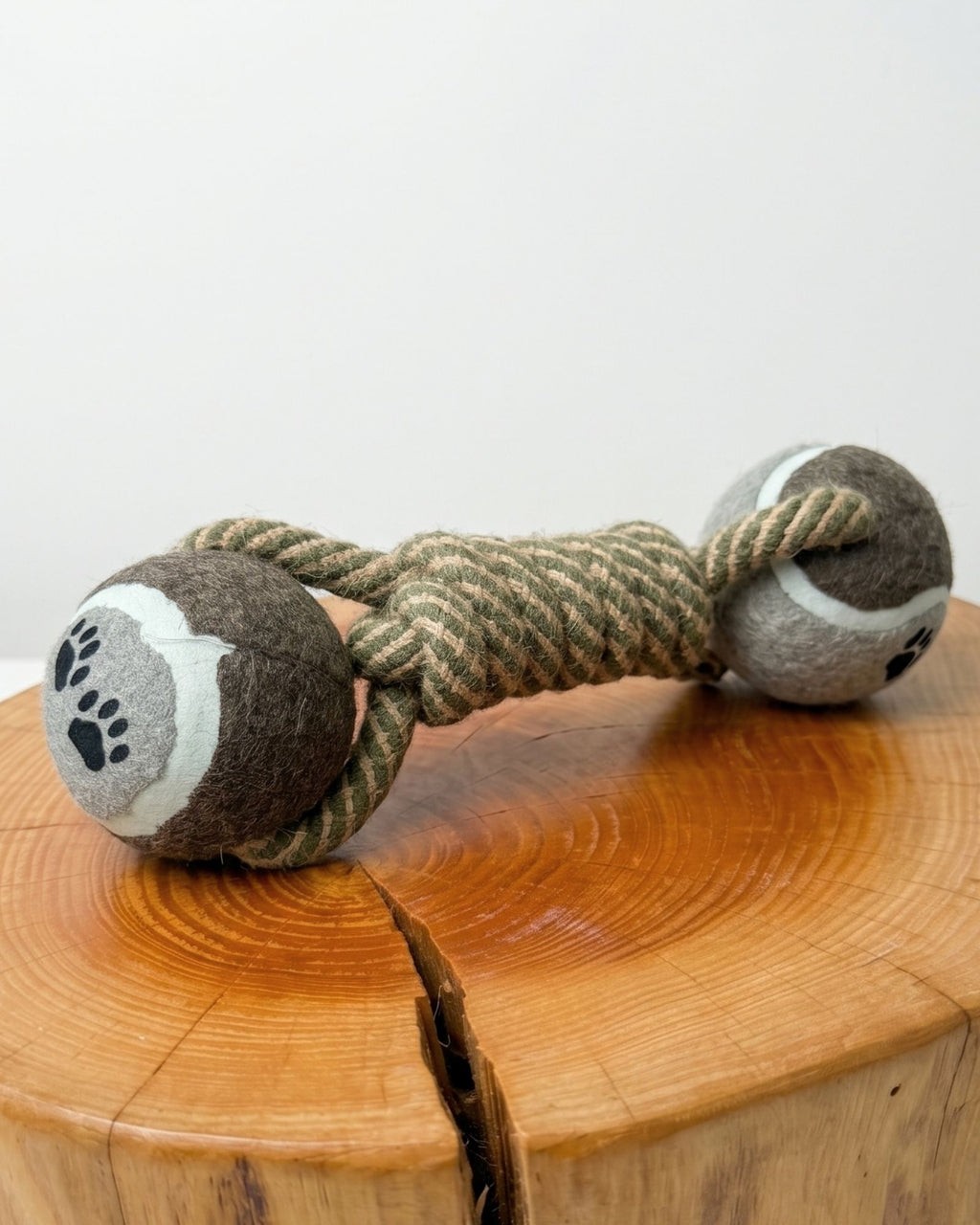 Dog toy with rope and paw pattern on a wooden surface